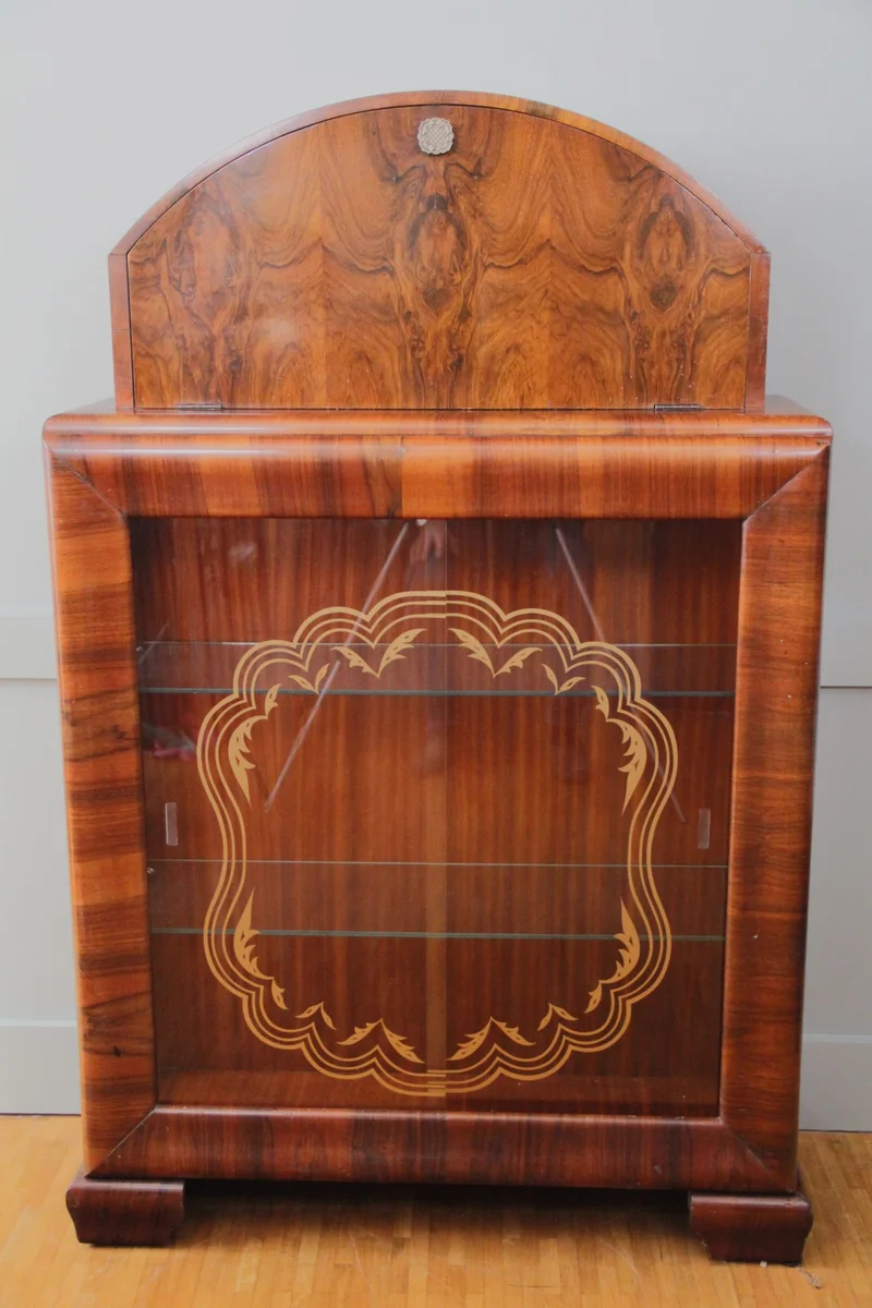 Art déco barmeubel - Meubel › Kasten - €950.00 - Vitrinekast - barmeubel in notenhout, handgepolitoerd.
Vitrinekast onderaan met glas op drie zijden; schuifdeuren met originele beschildering. Bargedeelte in gesloten bovenkast met originele spiegels.
91 x 31cm; 146cm hoog.
Periode 1930/1940