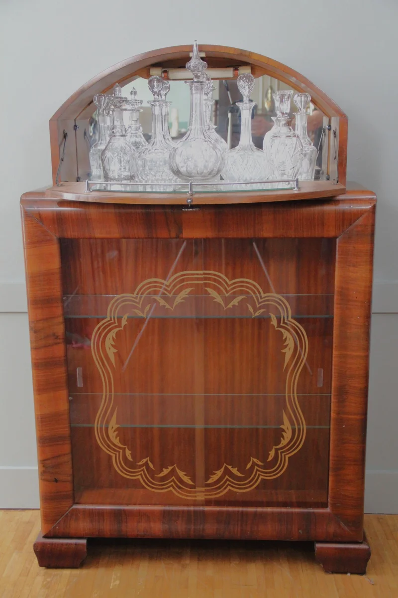 Art déco barmeubel - Meubel › Kasten - €950.00 - Vitrinekast - barmeubel in notenhout, handgepolitoerd.
Vitrinekast onderaan met glas op drie zijden; schuifdeuren met originele beschildering. Bargedeelte in gesloten bovenkast met originele spiegels.
91 x 31cm; 146cm hoog.
Periode 1930/1940