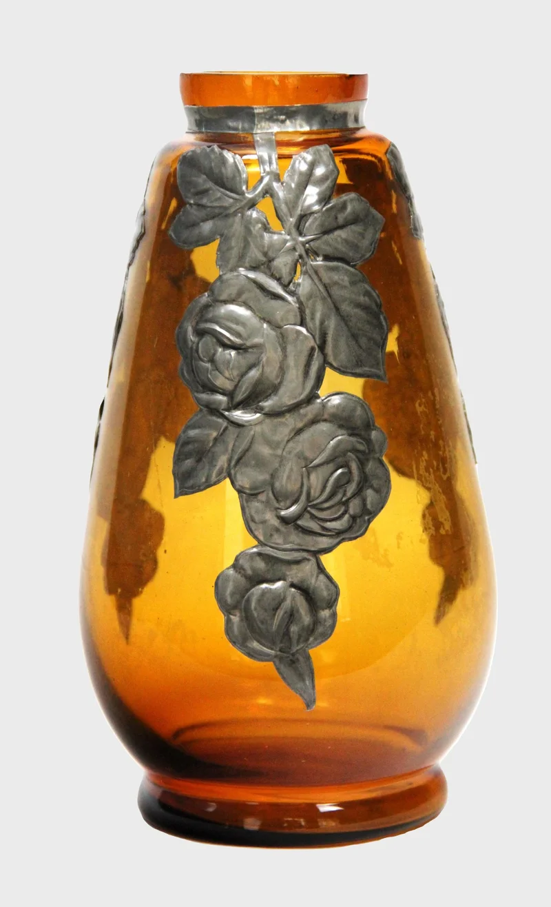 Art décovaas met tinbeslag - Glas › Vazen - €45.00 - Mondgeblazen doorgekleurd amberkleurig glas met rondom tinbeslag.
12cm diameter, 22cm hoog.
Ca 1930