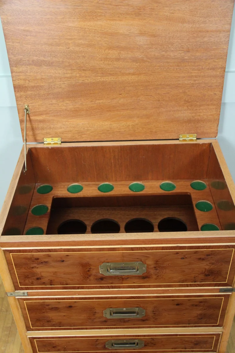 Campaigne barmeubeltje - Meubel › Kasten - €595.00 - Barmeubeltje met koperbeslag op de hoeken en 2 draaggrepen op de zijkanten. In de vorm van een kleine ladenkast, één lade onderaan en twee valse laden. Bargedeelte gaat bovenaan open; binnenin plaats voor 12 glaasjes en 8 flessen.
Afgewerkt in esdoorn en esdoornwortel hout.
Georgean stijl, vintage periode ca 1960/1970
58 x 40cm; 61cm hoog