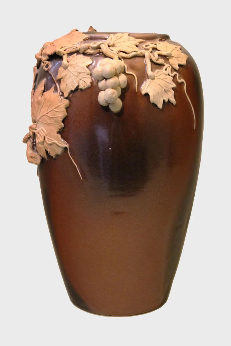 Vaas in terracotta - Porselein › Vazen - €125.00 - Bruin geglazuurde vaas met terracotta druivendecoratie bovenaan.
32cm hoog
1930-1950