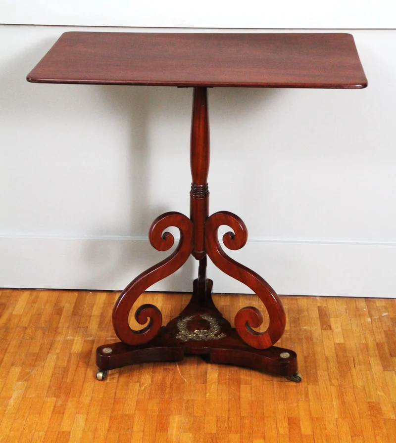 Vroegvictoriaans bijzettafeltje - Meubel › Tafels - €695.00 - Bijzettafeltje in cubaans mahonie op driespant, liermotieven en bronzen lauwerkrans.
63.5 x 42.5cm, 68.5cm hoog
Vroegvictoriaanse periode, ca 1830/1840
Gepolitoerd op oude wijze
